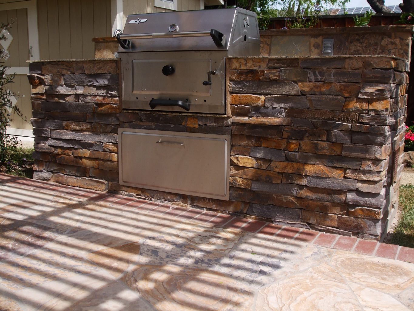 custom bbq with stone veneer on flagstone patio