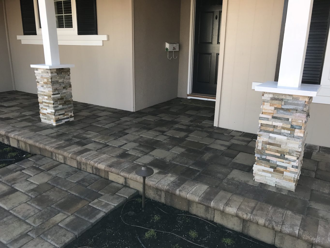 paver step and porch with stone veneer columns and wood cap