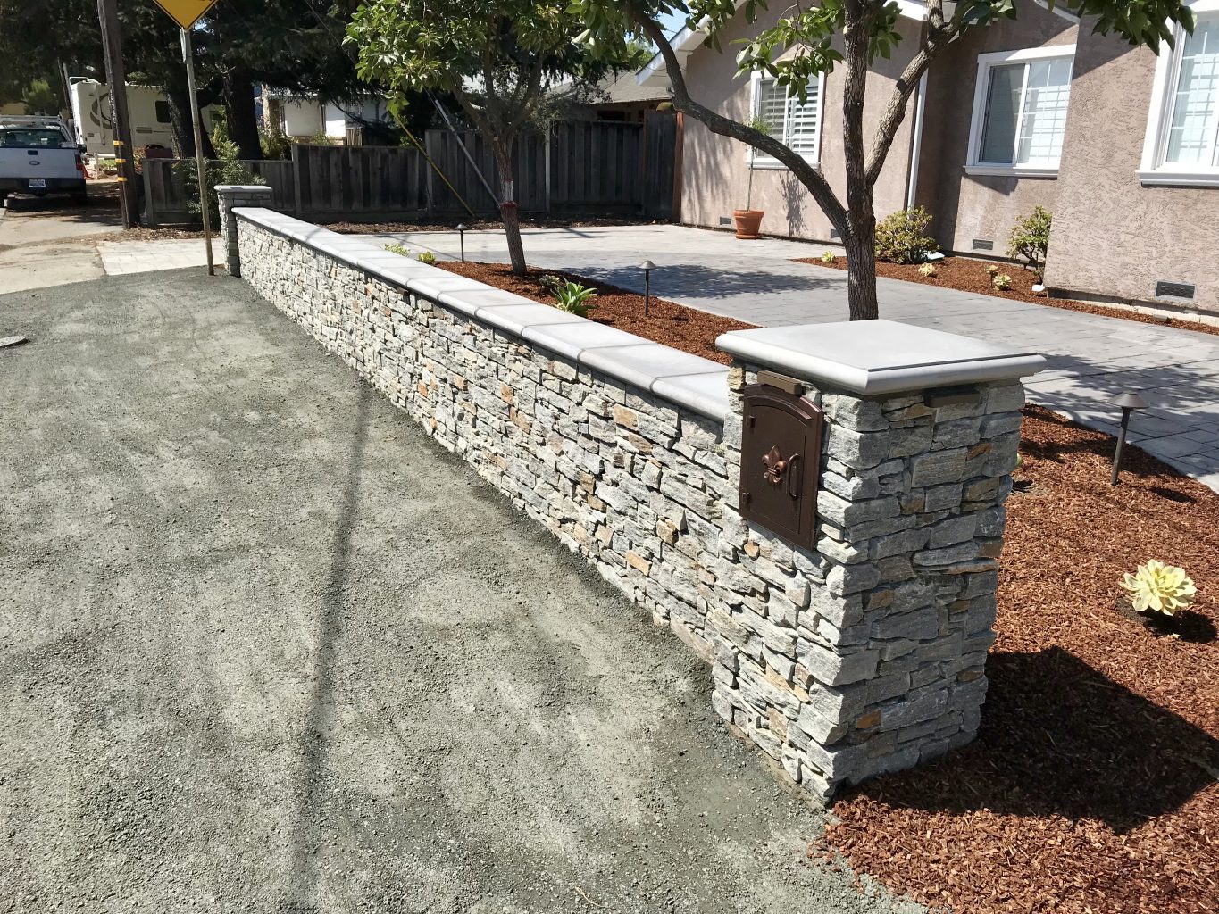 stone veneer columns and wall with concrete caps